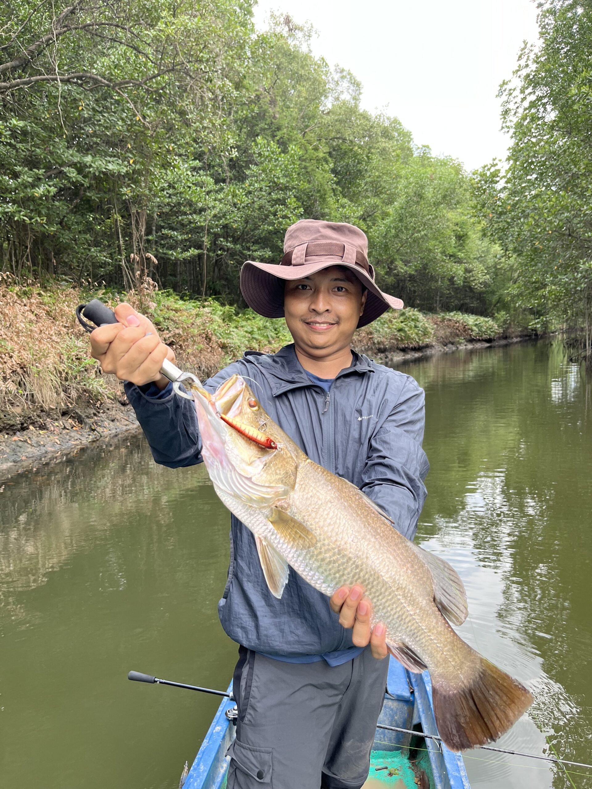 Tourist holding freshly caught fish during mangrove fishing trip in Vietnam