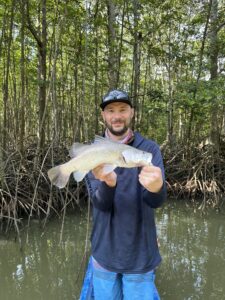 Angler casting fishing lure in Vietnam mangrove forest waters