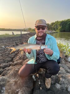 Tourist casting fishing rod in shallow salt field lakes of Vietnam
