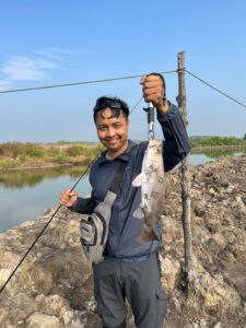 Tourist casting fishing rod in shallow salt field lakes of Vietnam
